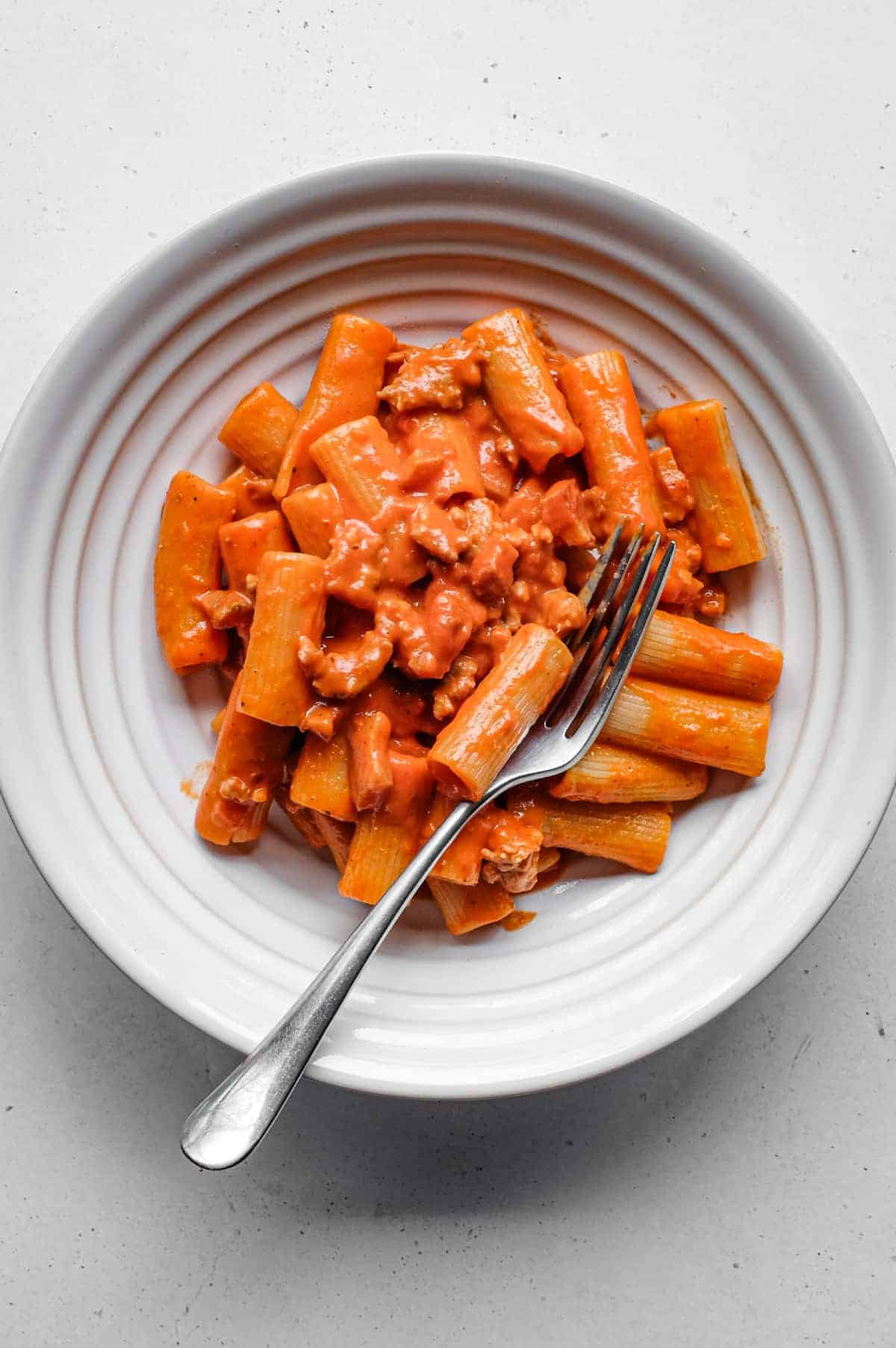 Pasta Alla Zozzona – cookeatworld.com A bowl of Pasta Alla Zozzona in a rich tomato sauce with a fork.