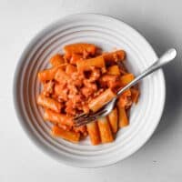 A bowl of Pasta Alla Zozzona in a rich tomato sauce with a fork.