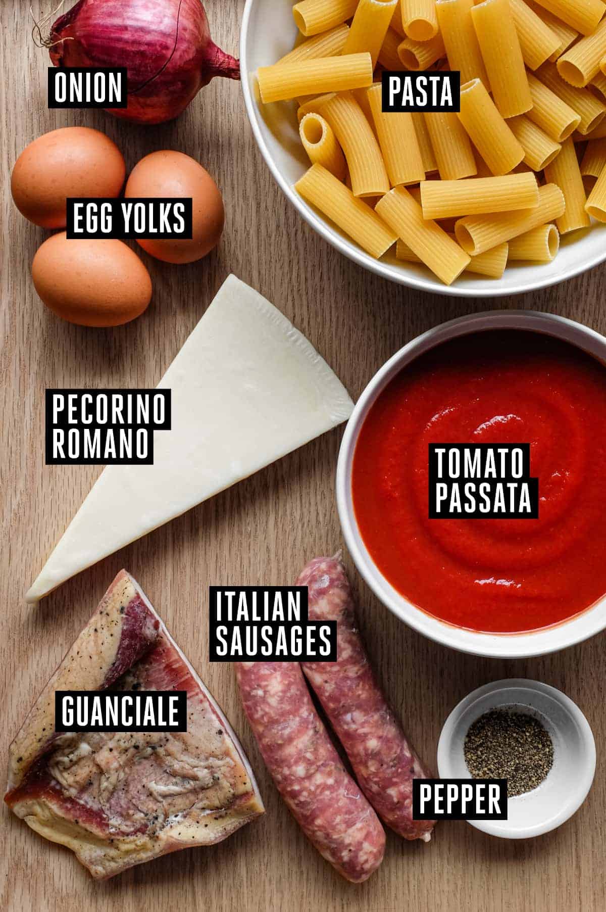 Pasta Alla Zozzona – cookeatworld.com the ingredients for Pasta Alla Zozzona: from the top down... Onion, Rigatoni pasta, eggs, cheese, tomato passata, guanciale bacon, italian sausages and black pepper.