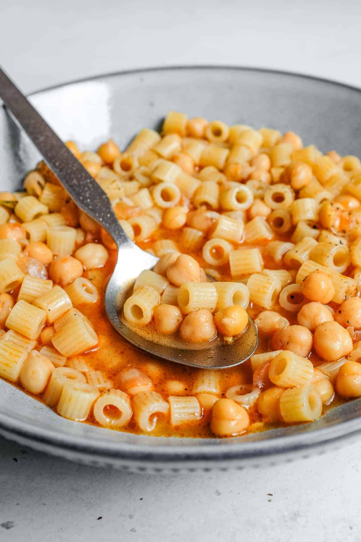 a bowl of Italian pasta e ceci with a spoon