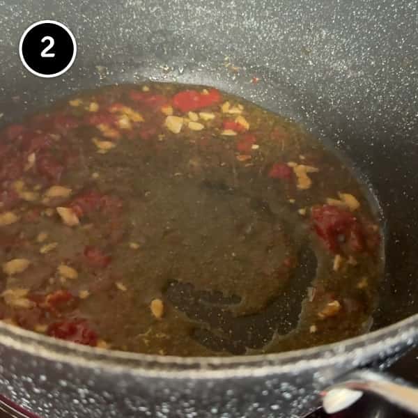 Pasta e Ceci – Italian Pasta with Chickpeas | cookeatworld.com frying garlic, anchovies and tomato paste in a pot