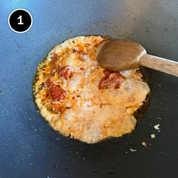 Thai Red Curry Noodles (Easy Vegetarian Recipe) | cookeatworld.com Thai red curry paste and coconut milk are combined in a wok.