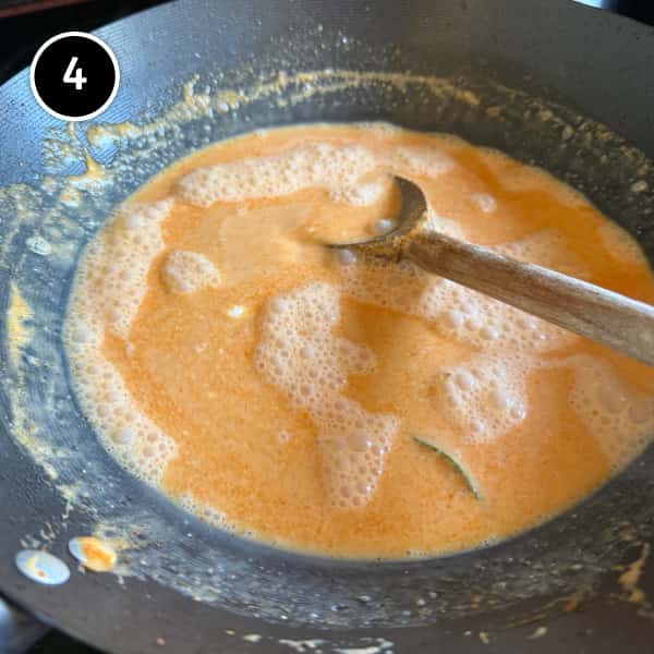 Thai Red Curry Noodles (Easy Vegetarian Recipe) | cookeatworld.com Stirring the Thai red curry coconut broth in a wok.
