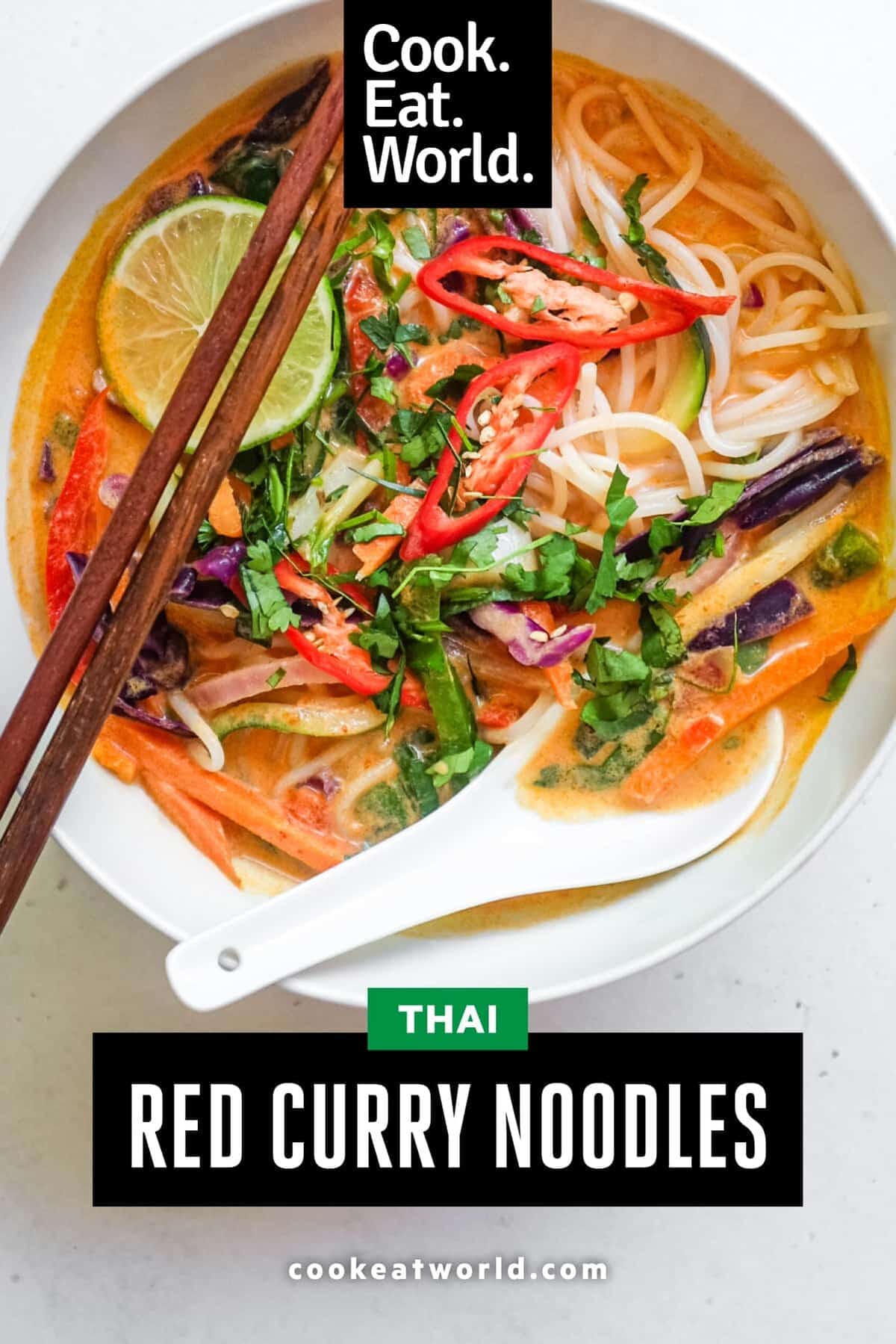 An overhead view of a bowl of Thai red curry noodles with fresh vegetables.