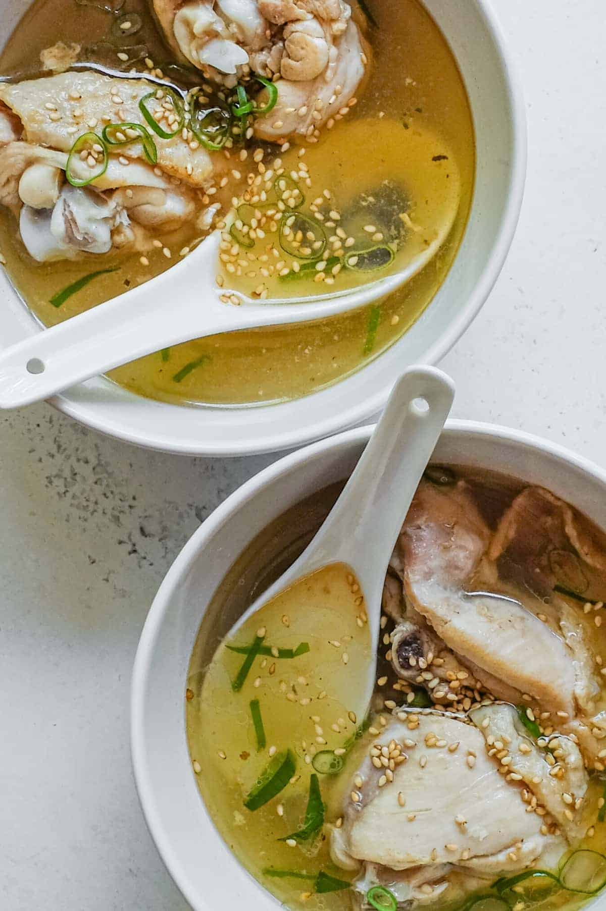 An overhead angle featuring two bowls of Taiwanese Sesame Oil Chicken Soup