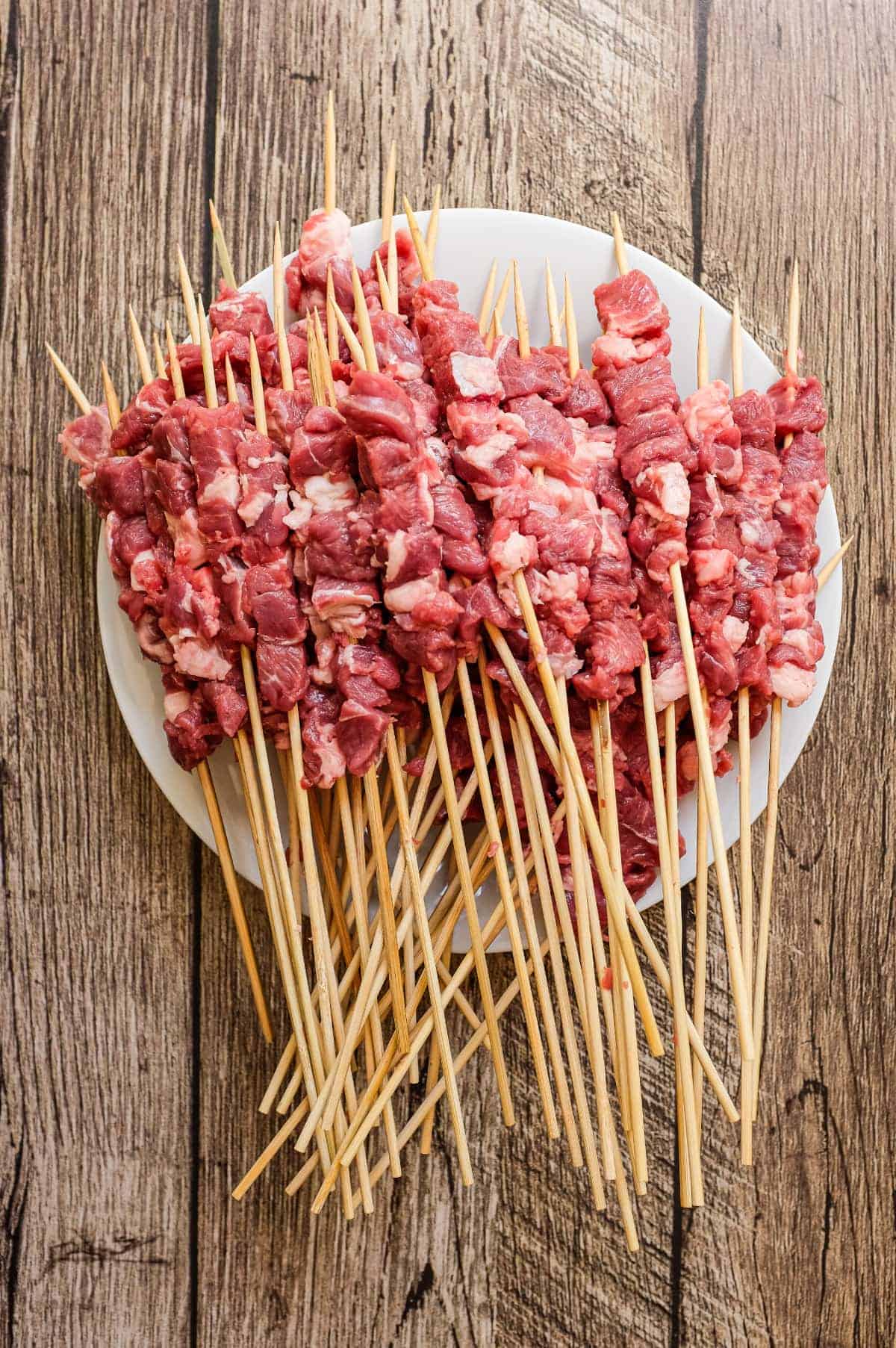 Arrosticini (Italian Lamb Skewers) | cookeatworld.com Uncooked arrosticini skewers with raw lamb and fat cubes threaded onto sticks
