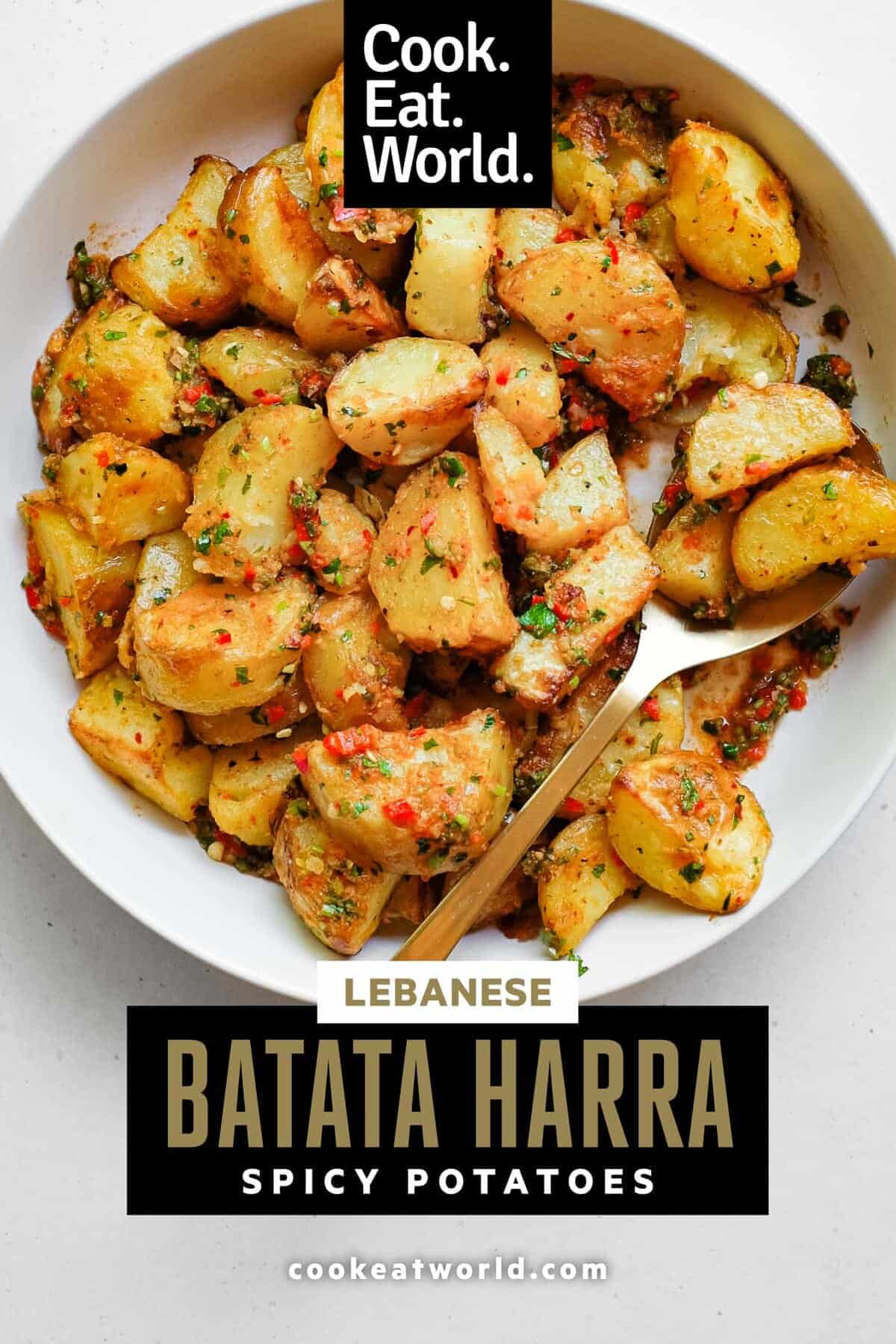 A serving bowl filled with spicy lebanese roast potatoes (batata harra).