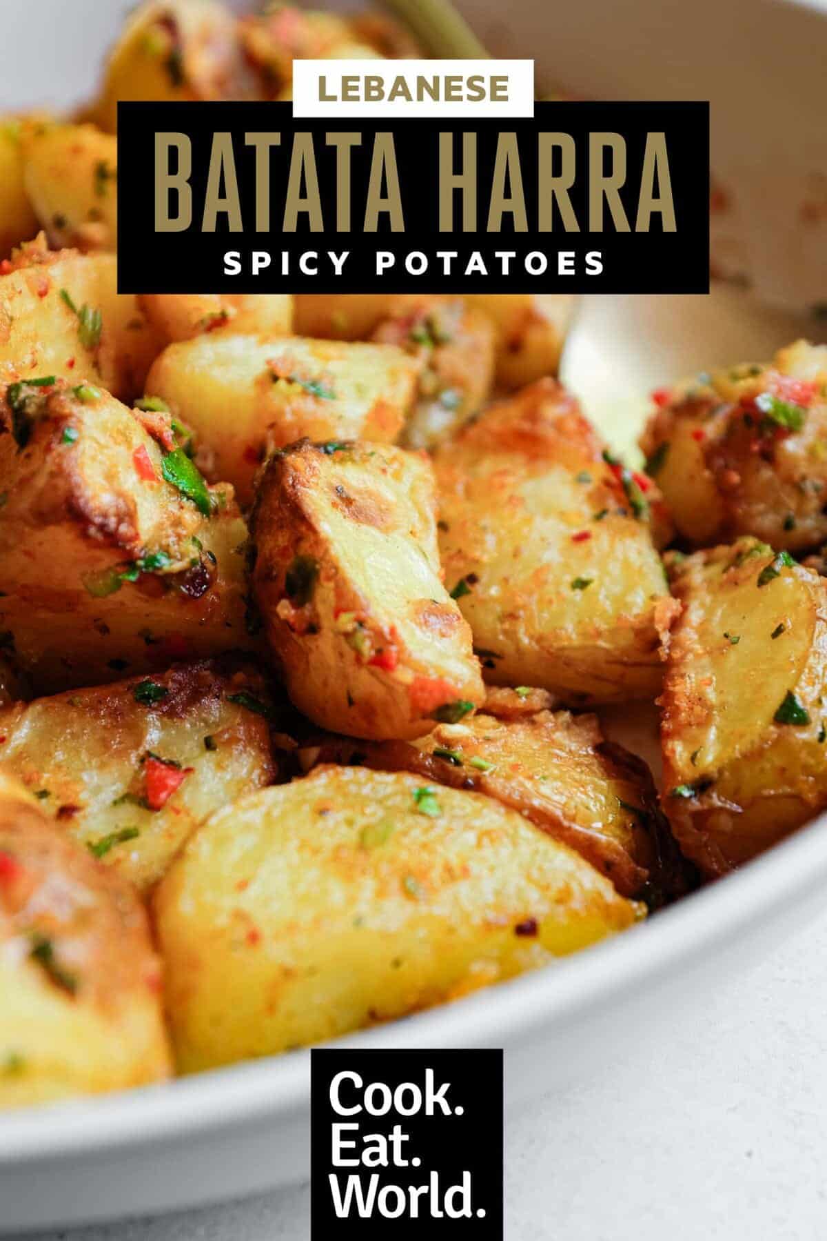 A serving bowl filled with spicy lebanese roast potatoes (batata harra).