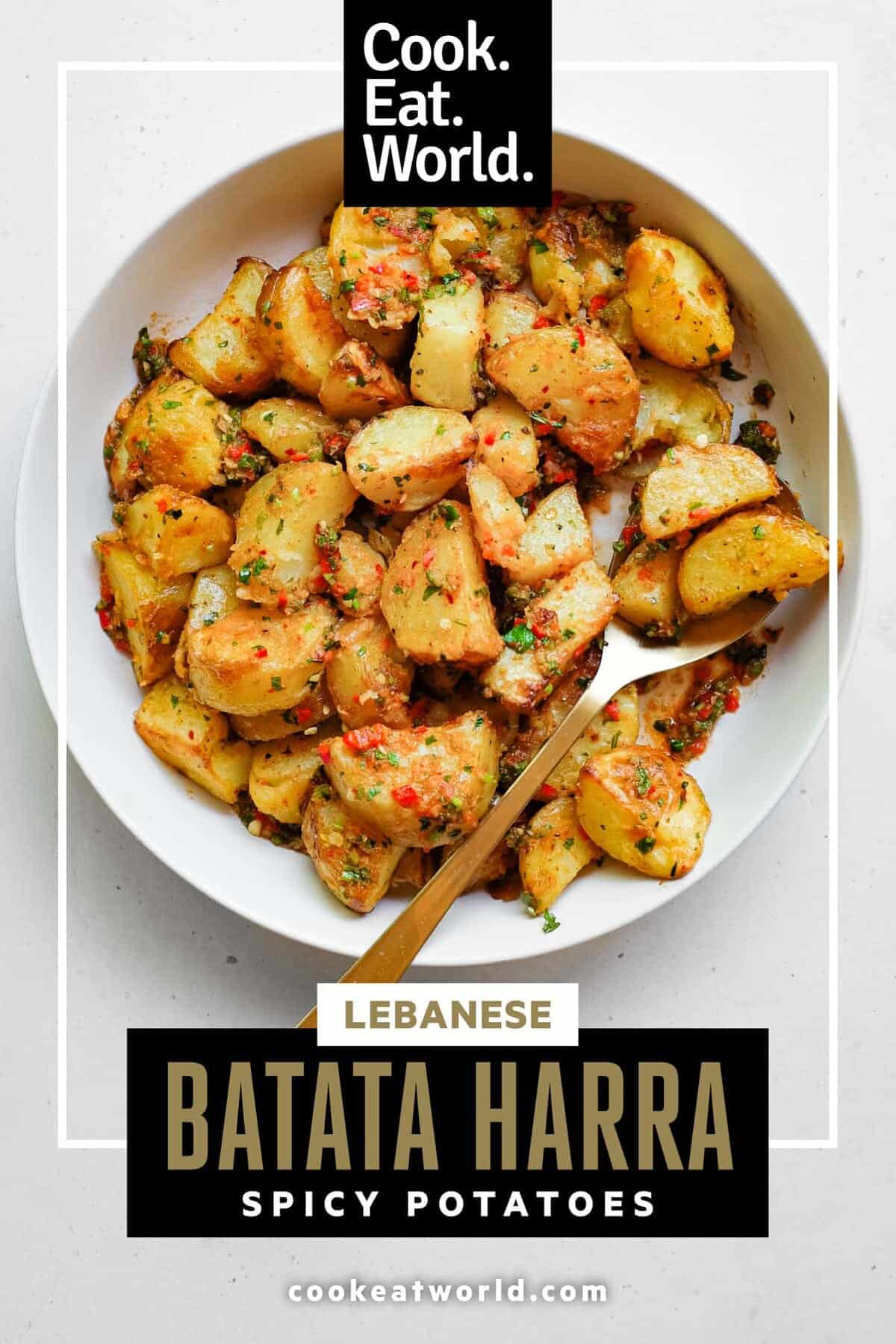 A serving bowl filled with spicy lebanese roast potatoes (batata harra).