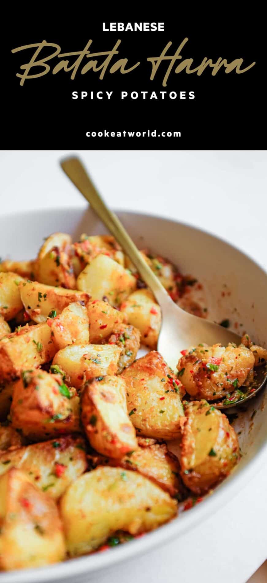 A serving bowl filled with spicy lebanese roast potatoes (batata harra).