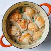 Family-style pan filled with crisp-skinned chicken thighs nestled into a bed of creamy cannellini beans and fennel.