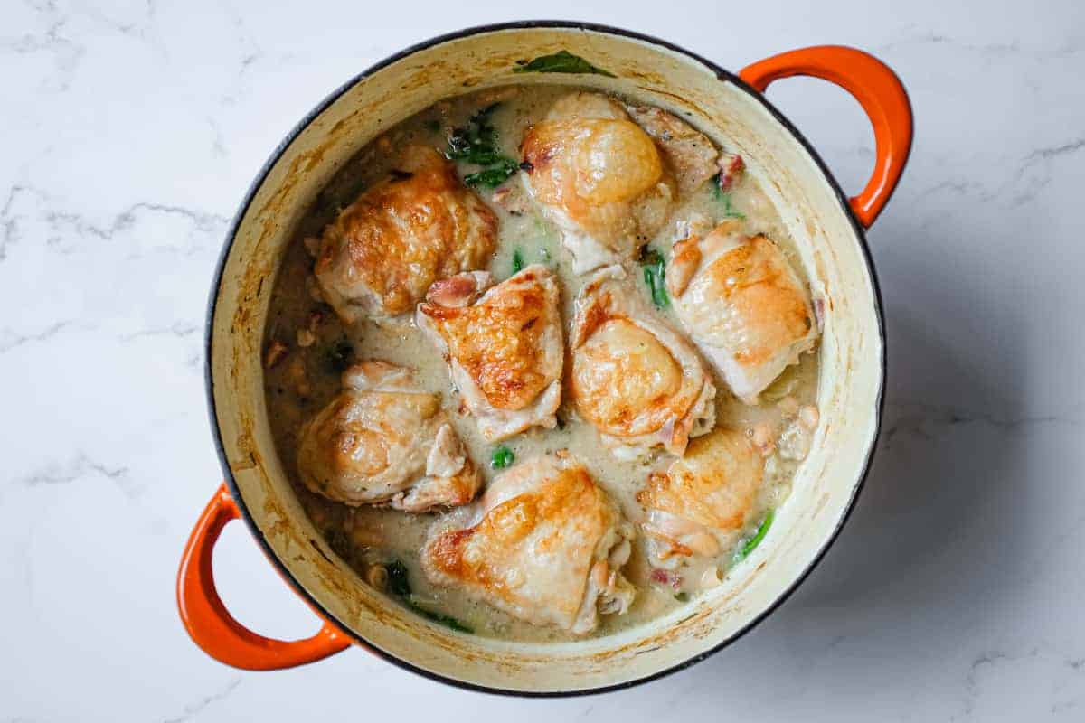 Family-style pan filled with crisp-skinned chicken thighs nestled into a bed of creamy cannellini beans and fennel.