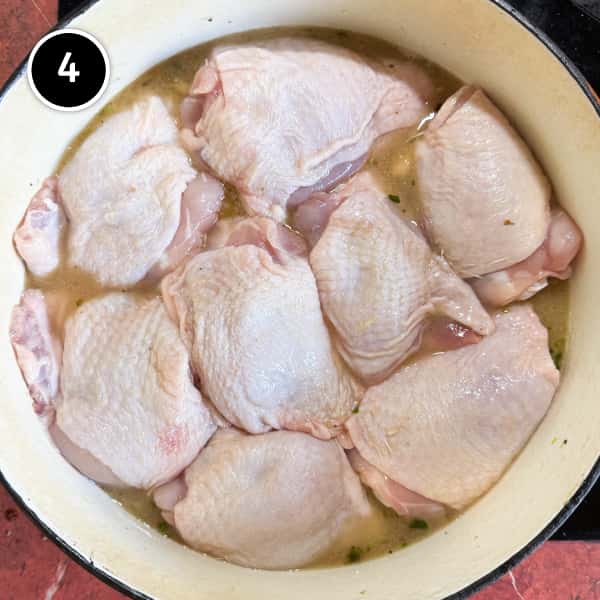 Italian Chicken Thighs with Cannellini Beans and Fennel | cookeatworld.com The raw chicken thighs are arranged skin-side up in the Dutch oven