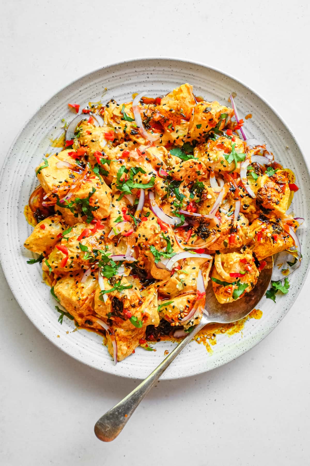 A platter of creamy Aloo Chukauni, a Nepali potato and yoghurt salad garnished with a vibrant spiced oil