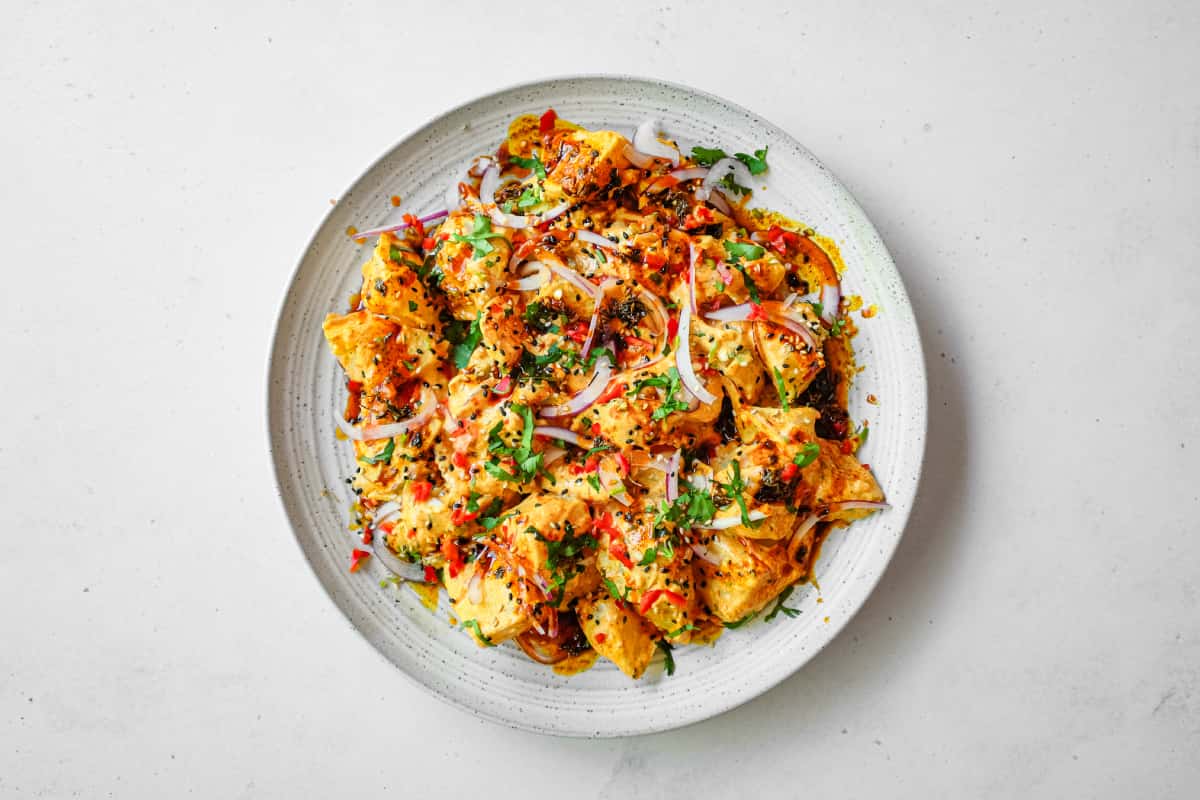 A platter of creamy Aloo Chukauni, a Nepali potato and yoghurt salad garnished with a vibrant spiced oil