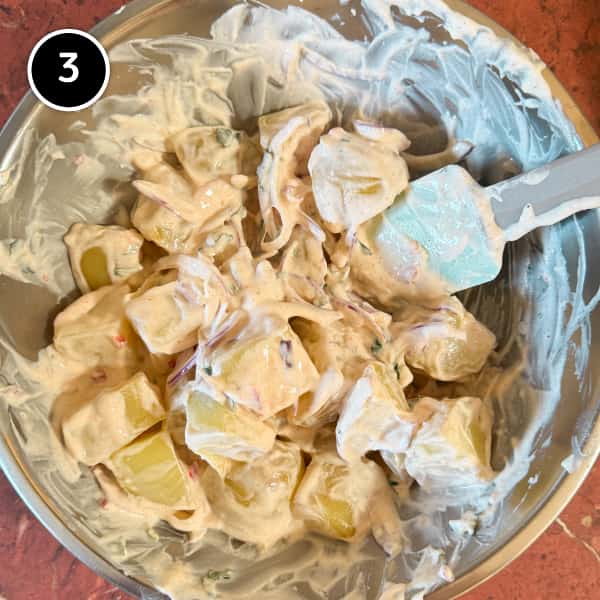 Aloo Chukauni – Nepali Yoghurt-Spiced Potatoes | cookeatworld.com Potatoes being mixed into a yoghurt sauce