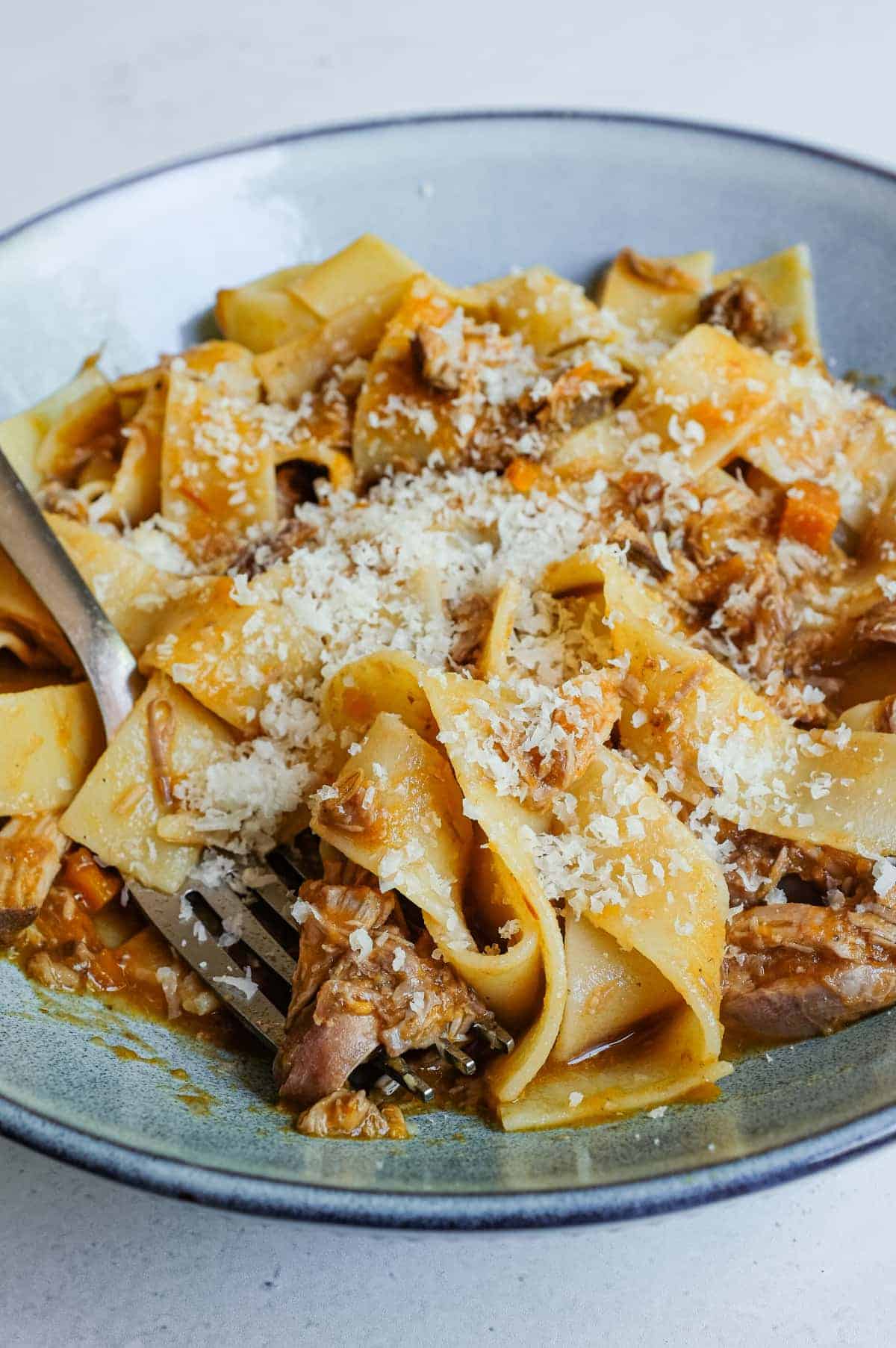 Parmigiano Reggiano is scattered over a hearty bowl of pappardelle with duck rag&ugrave;