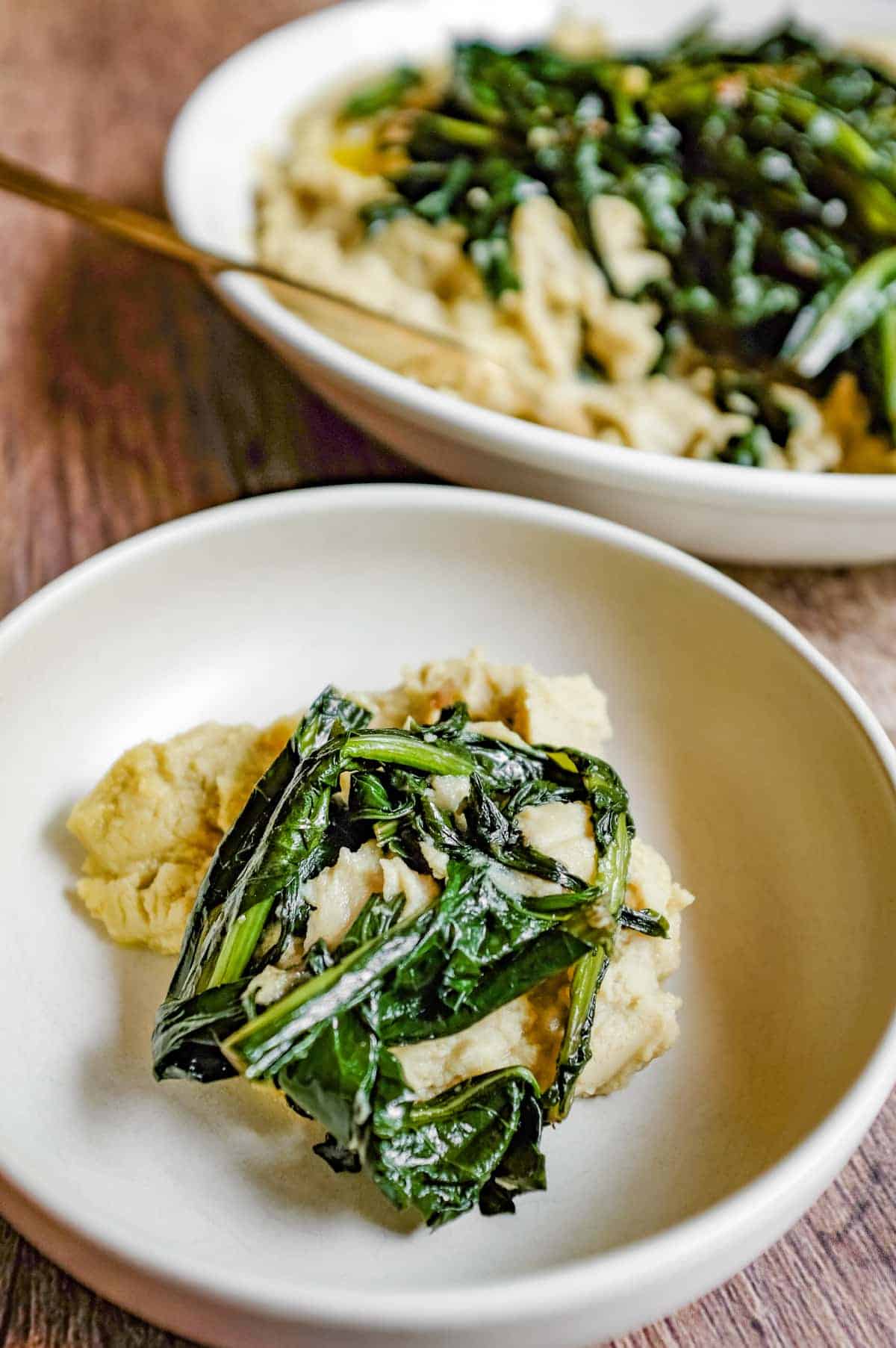 Two bowls of fava bean puree and chicory greens