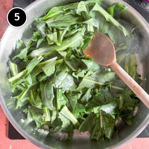 Fave e Cicoria (Puglian Fava Bean Purée with Chicory) | cookeatworld.com Chicory leaves in a frying pan with garlic.