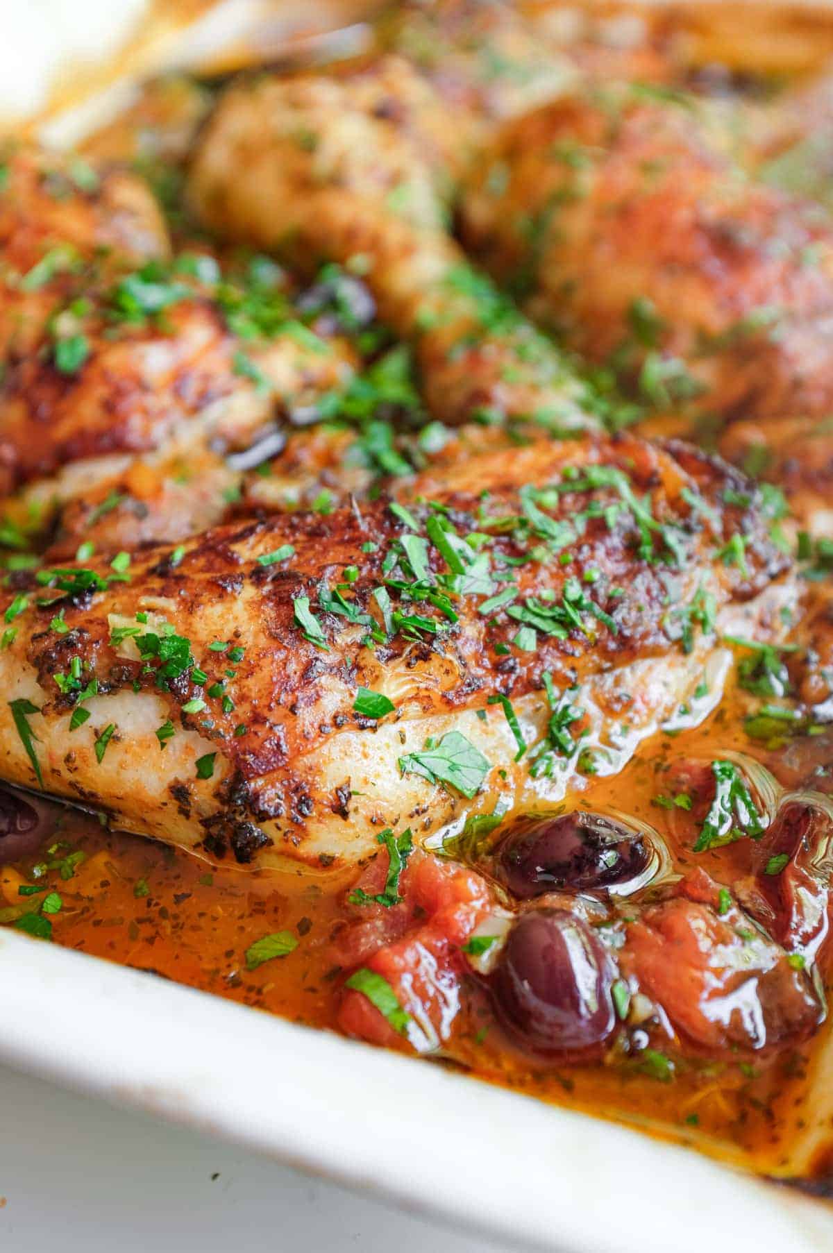 A vibrant harissa sauce from Morocco surrounds succulent roast chicken legs.
