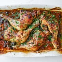 An overhead shot of a baking dish containing Moroccan harissa chicken.