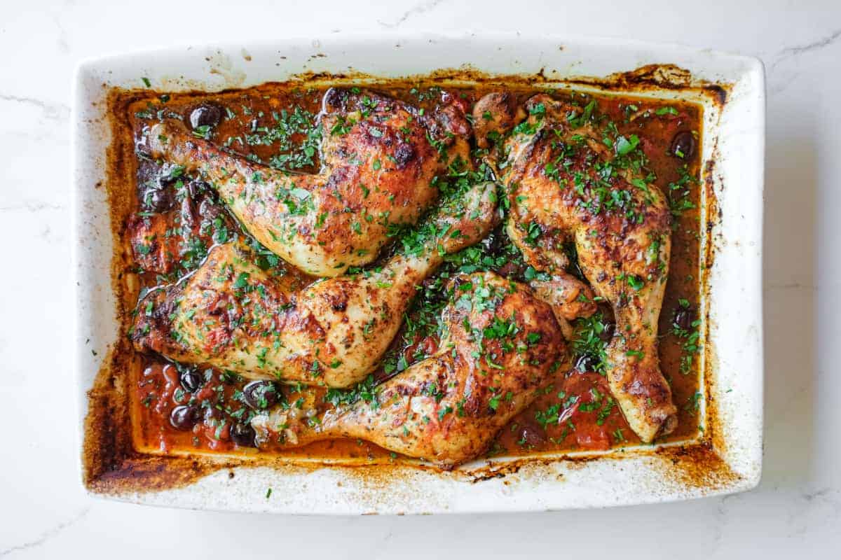 An overhead shot of a baking dish containing Moroccan harissa chicken.