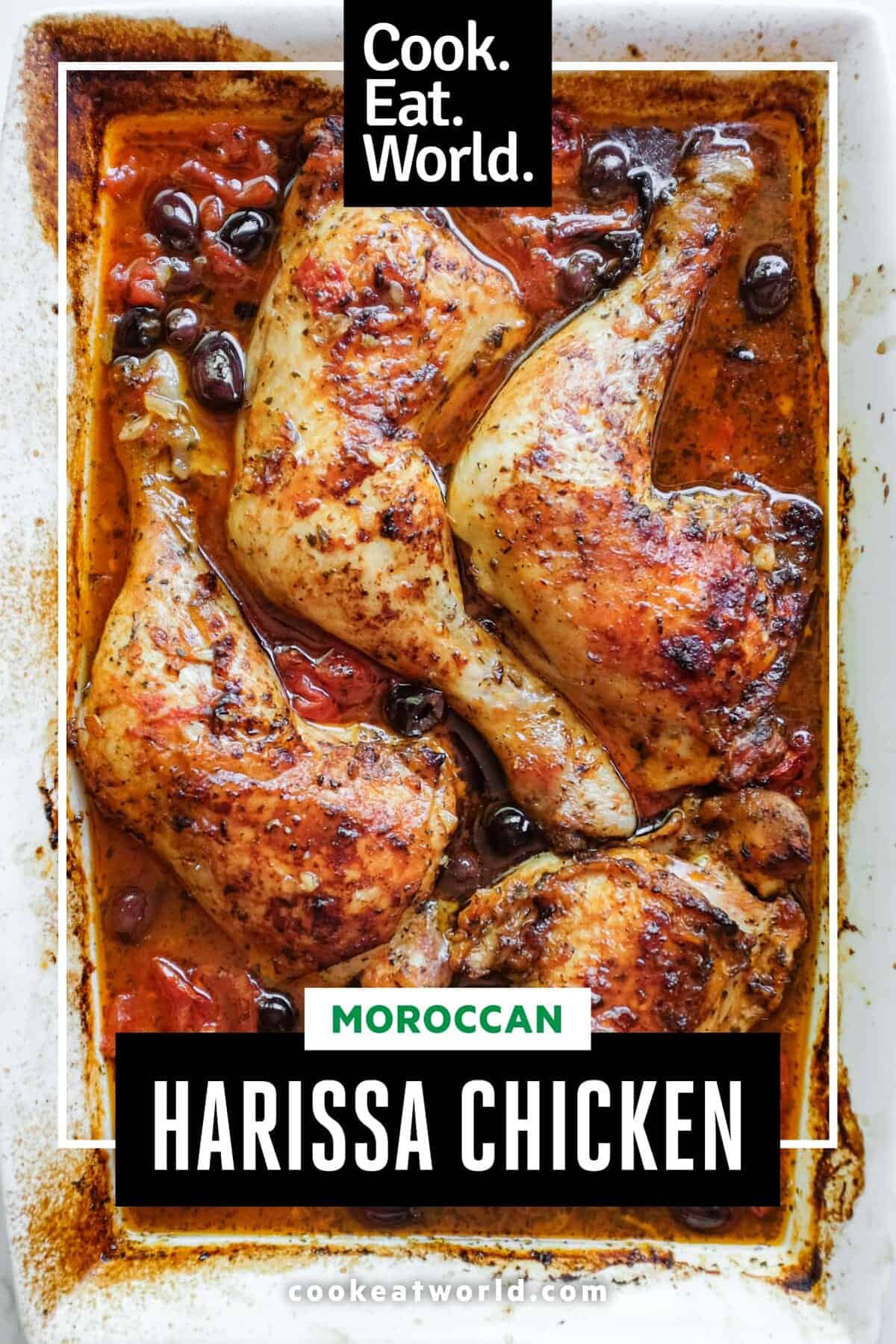 An overhead shot of a baking dish containing vivid harissa chicken pieces.