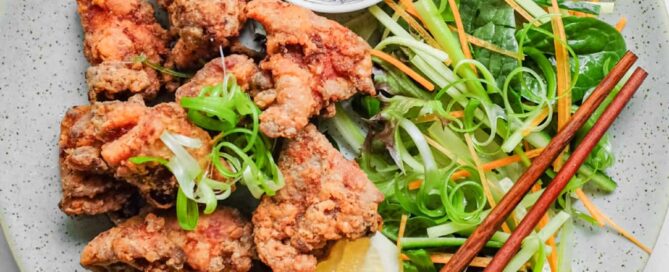A plate of Japennese karaage chicken with a side salad, lemon wedge, and mayonnaise