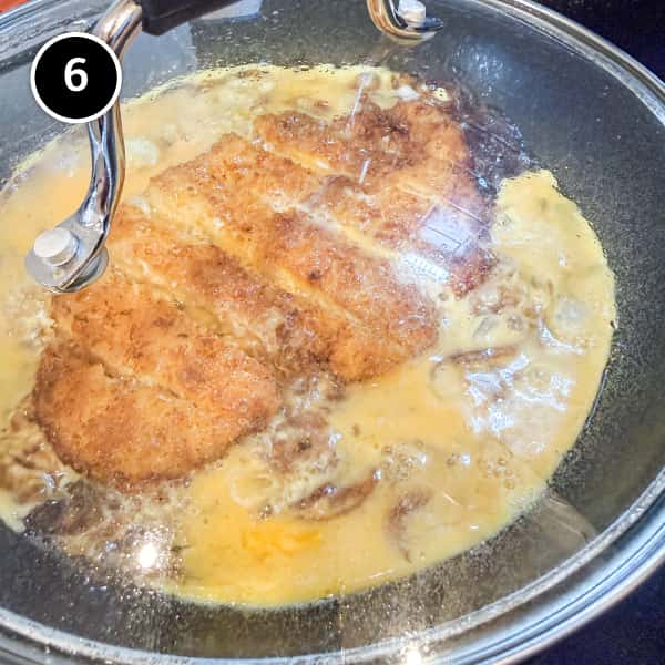 Chicken Katsudon | cookeatworld.com Eggs setting in a frying pan with chicken katsu.