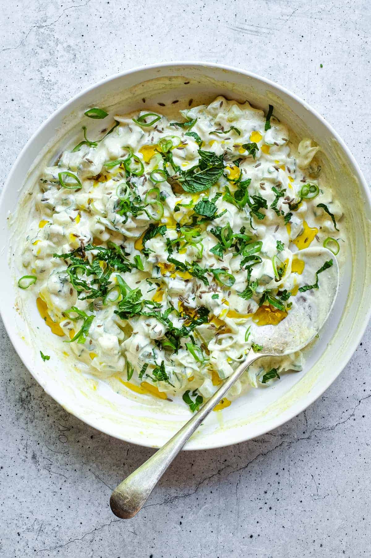 Indian cucumber raita with creamy yoghurt, fresh herbs and mustard oil garnish