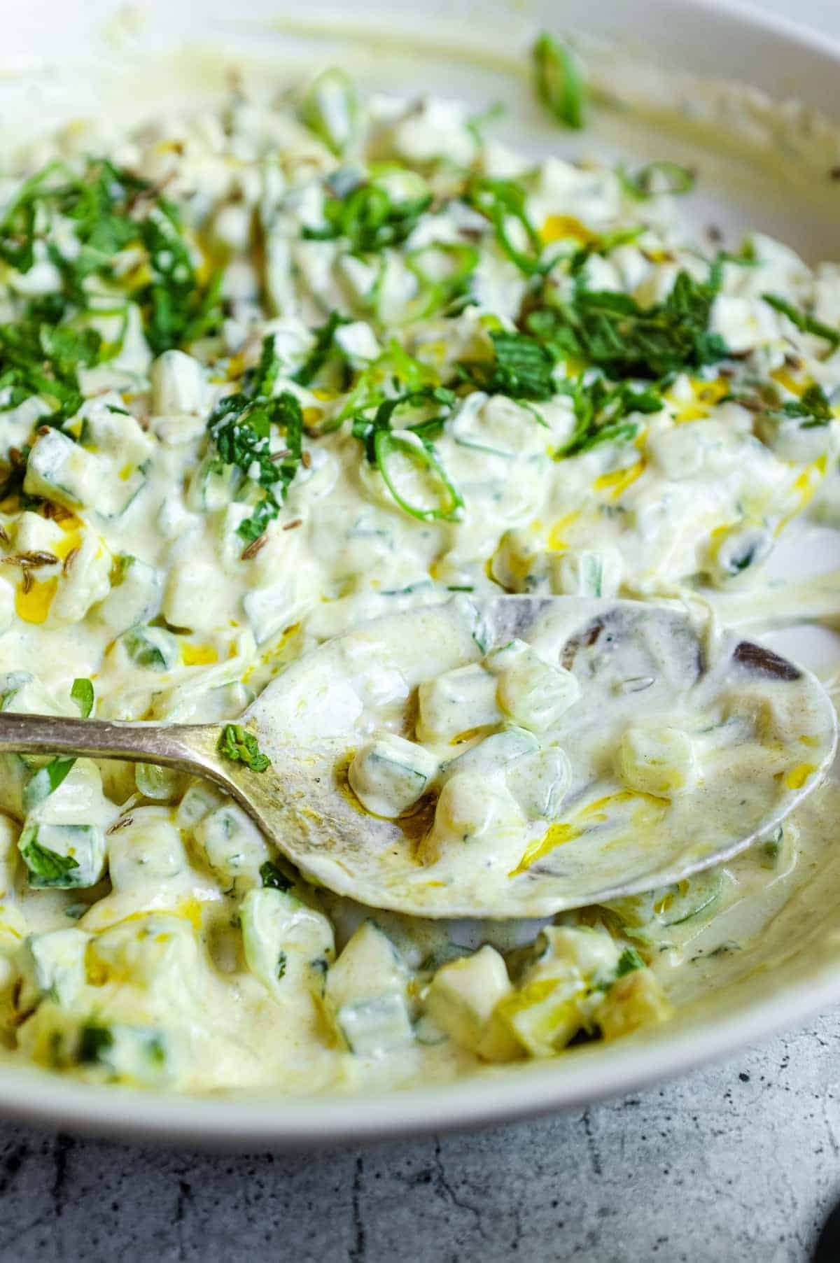 Freshly prepared cucumber raita with yoghurt, herbs and a light mustard oil drizzle