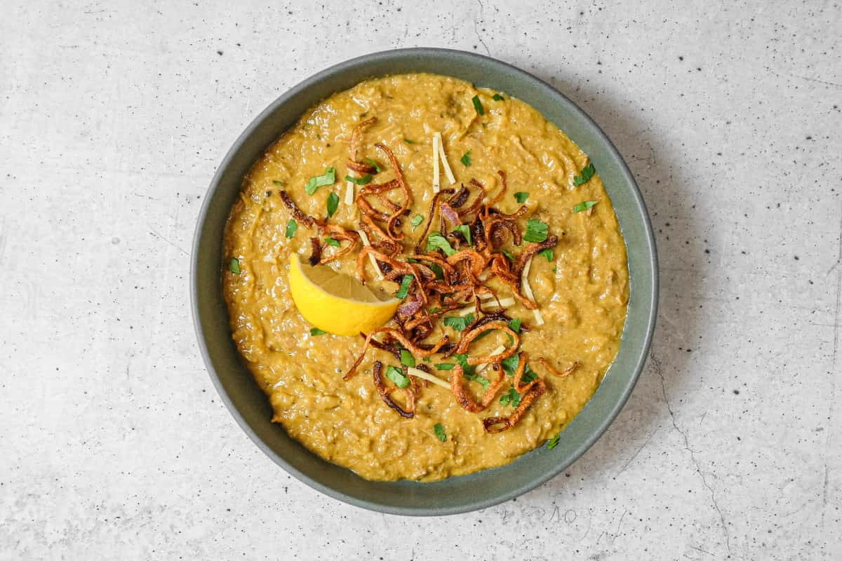Rich haleem with tender lamb, topped with fried onions and fresh cilantro