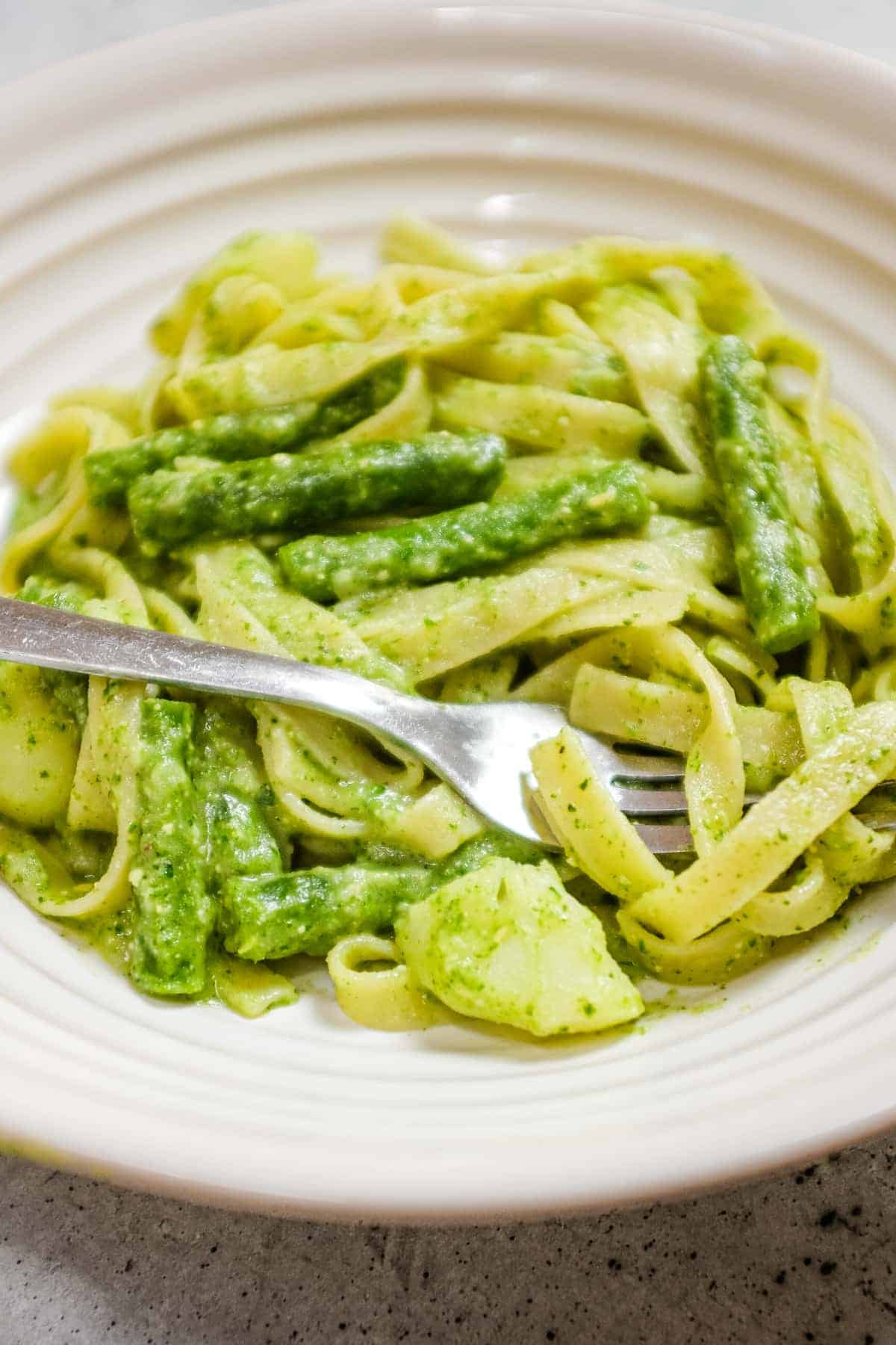 Close-up of pesto pasta with creamy potatoes and crisp green beans