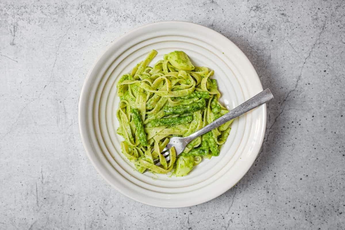 Homemade pesto pasta with potatoes and green beans served warm