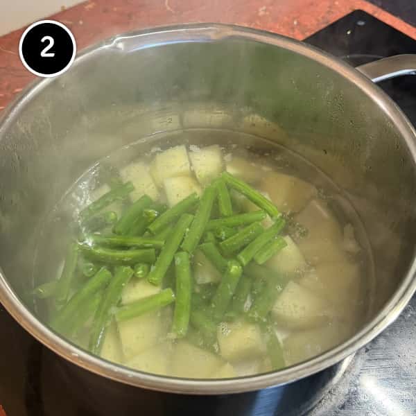Pesto Pasta with Potatoes & Green Beans (Trenette al Pesto) | cookeatworld.com potatoes and green beans cooking in a large pan of salted water.