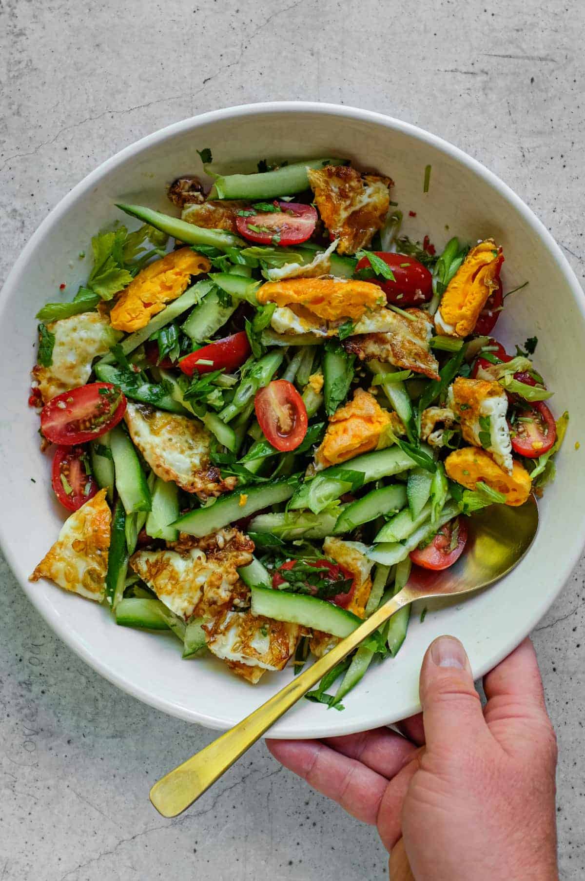 Thai fried egg salad served with cucumber, tomato and cilantro