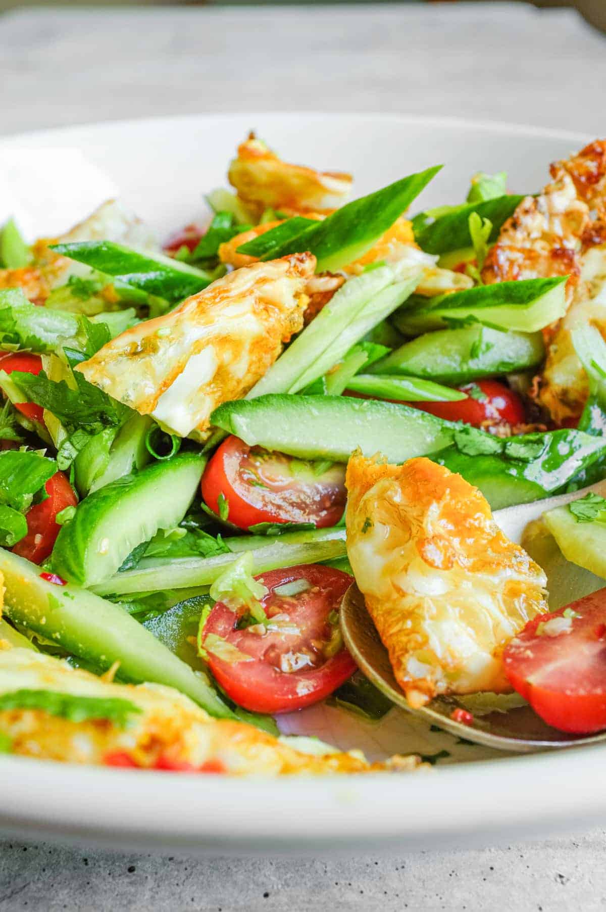 Yam kai dao plated with fresh herbs and spicy dressing