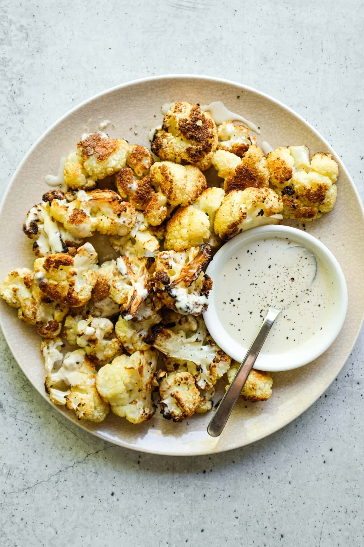 Arnabeet B’Tahini plated with charred cauliflower and sesame sauce