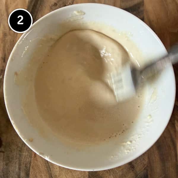 Lebanese Cauliflower with Tahini (Arnabeet b’Tahini) | cookeatworld.com Tahini sauce being whisked into a creamy dip for roasted cauliflower.