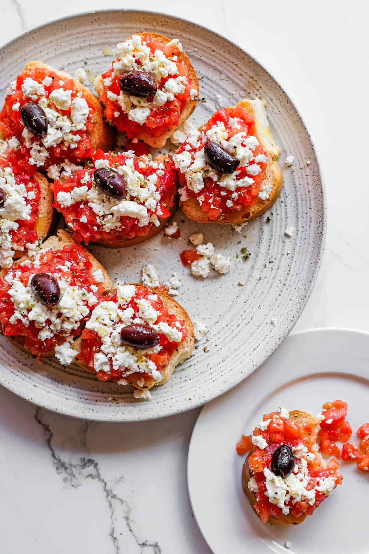 Cretan Dakos Salad | cookeatworld.com Authentic Cretan dakos served on a rustic platter with olives and oregano