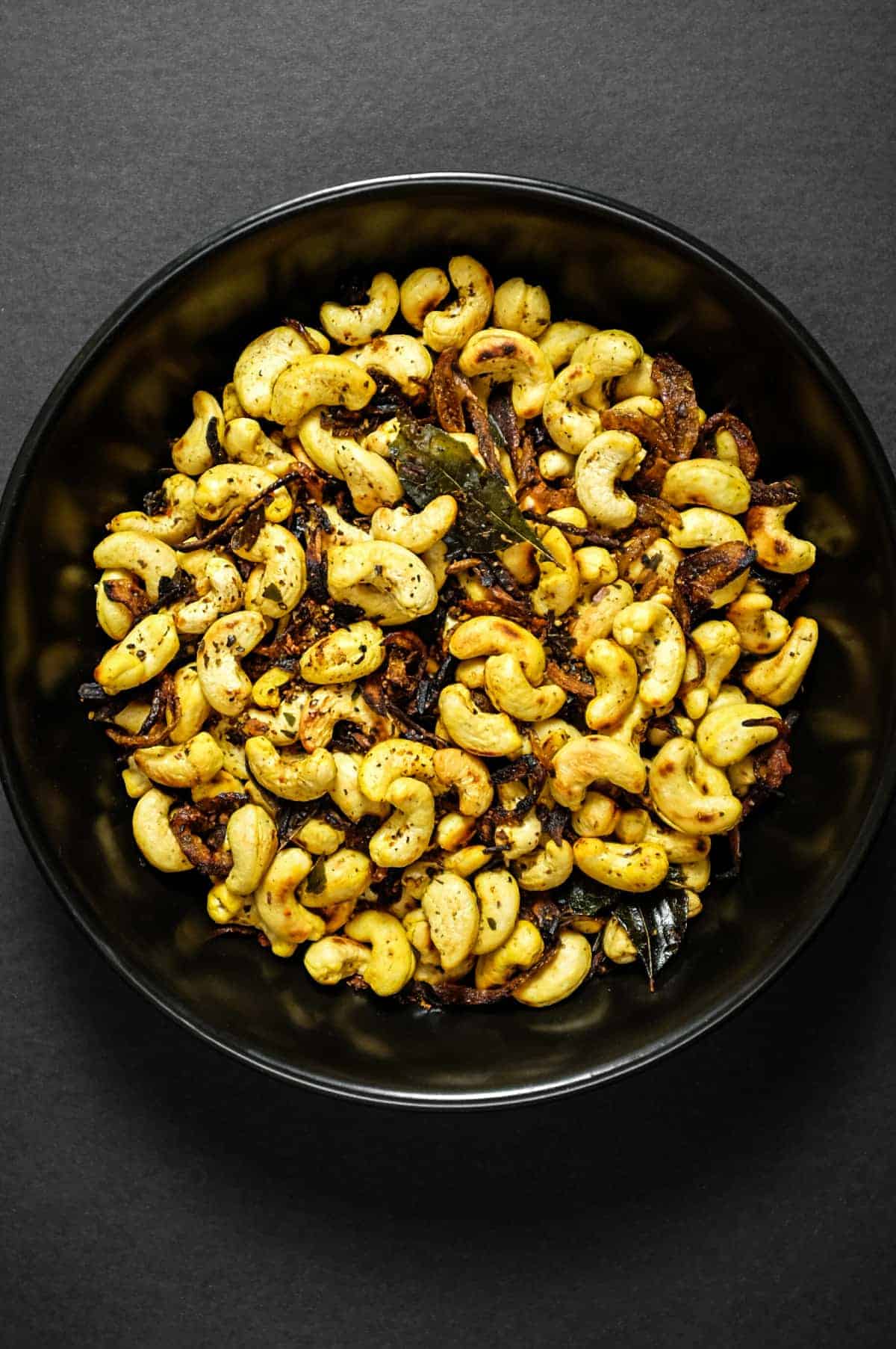 Crunchy South Indian curry leaf cashews served in a rustic bowl.