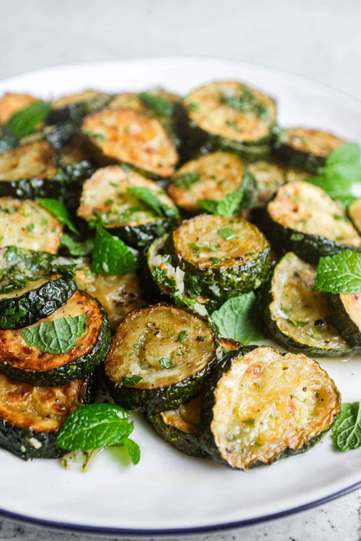 Traditional Italian zucchini alla scapece garnished with fresh mint leaves and served as a Mediterranean side dish.