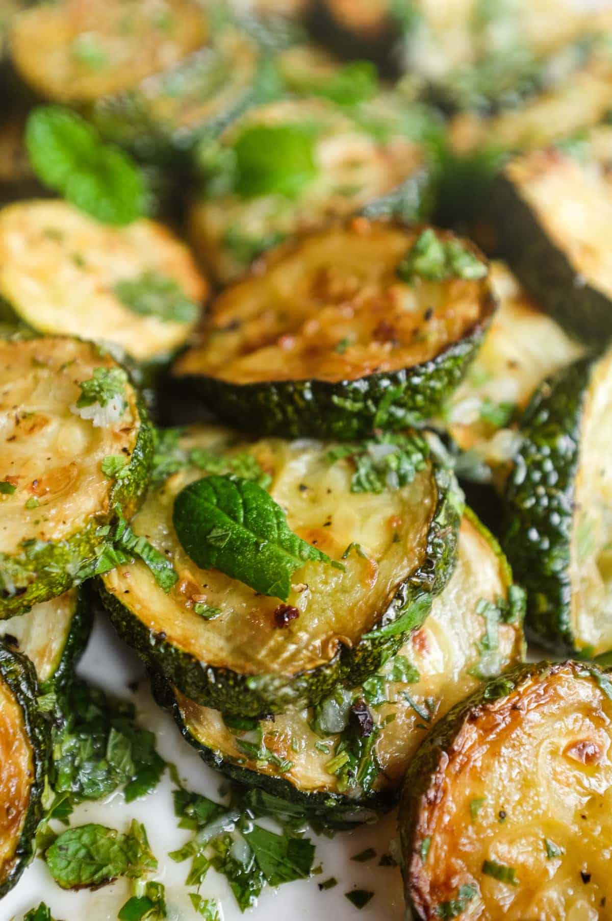 Close-up of fried zucchini slices coated in a tangy garlic and mint dressing for authentic zucchini alla scapece.