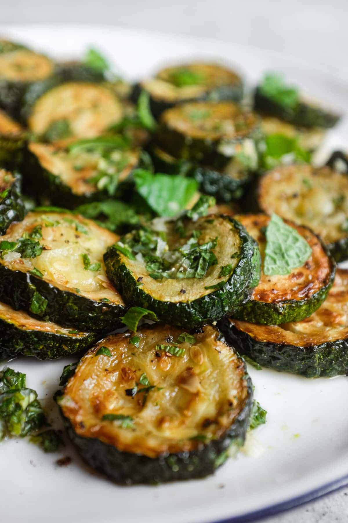 A rustic platter of zucchini alla scapece served at room temperature with fresh mint and cracked black pepper.