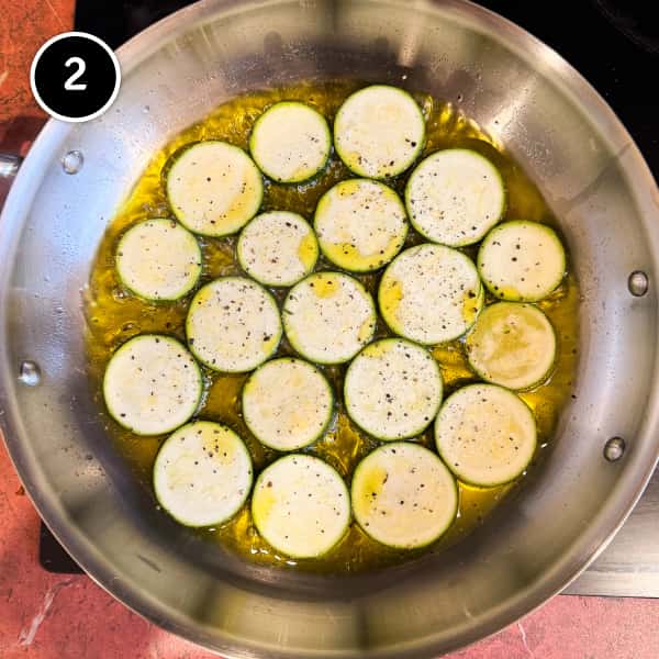 Zucchini Alla Scapece (Italian Zucchini with Mint & Vinegar) | cookeatworld.com Zucchini rounds frying in olive oil in a large frying pan