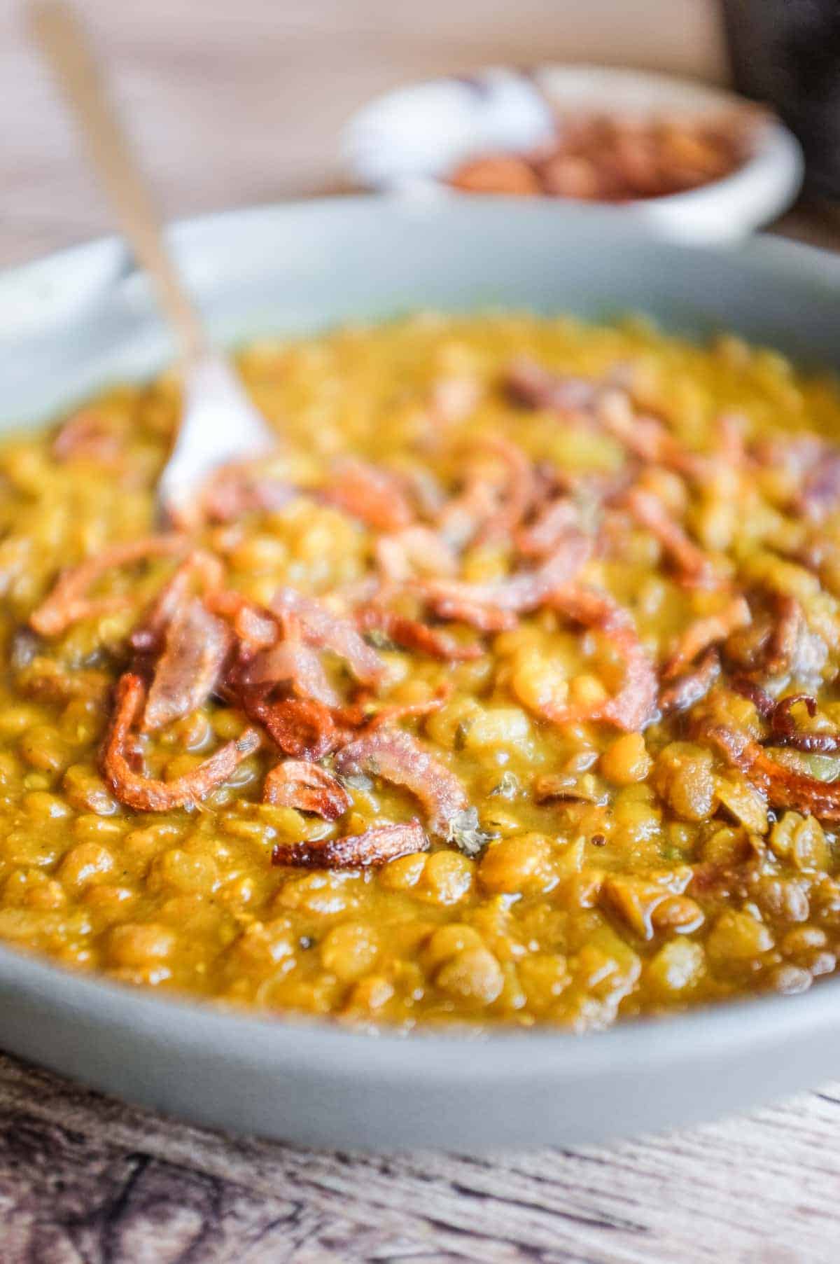 Creamy Iranian adasi with whole lentils and golden onion garnish