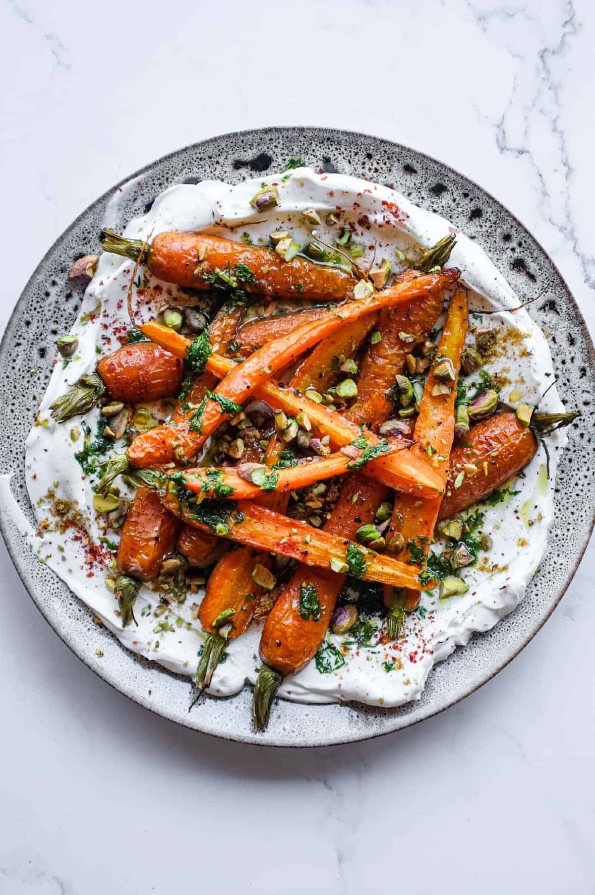 Roasted baby carrots served over creamy labneh with toasted pistachios, fresh dill and a drizzle of lemon dressing.
