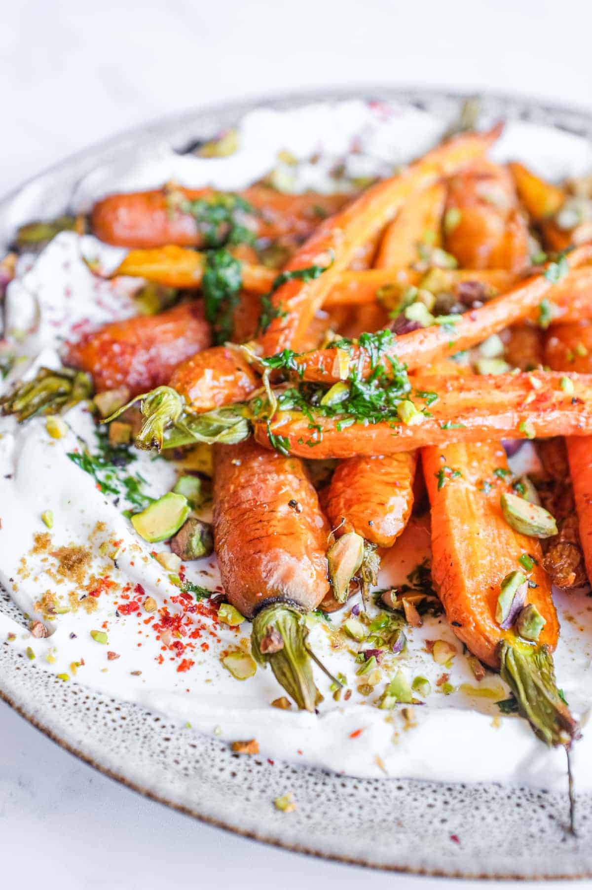 Middle Eastern roast carrot salad with creamy labneh, fresh herbs and toasted pistachios.