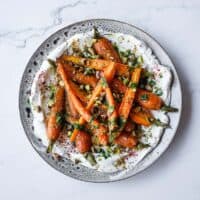 A fresh roast carrot side dish with creamy labneh, dill, lemon and crunchy pistachios.