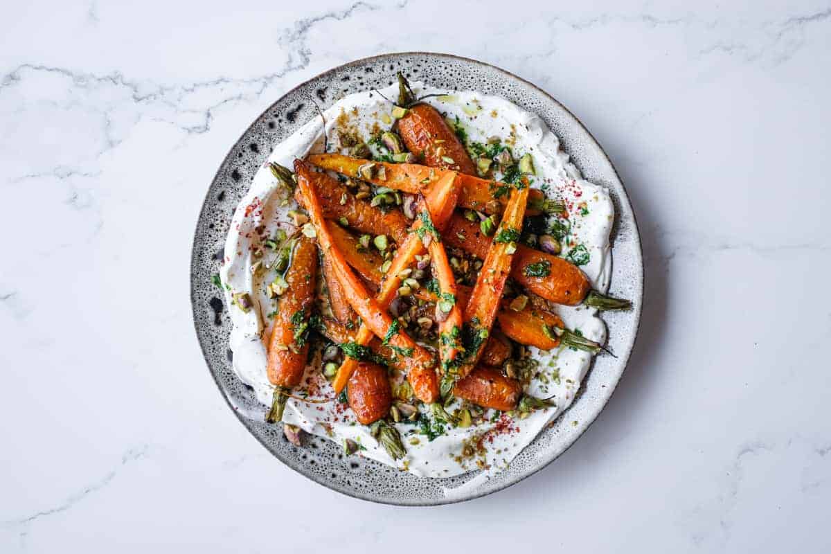 A fresh roast carrot side dish with creamy labneh, dill, lemon and crunchy pistachios.